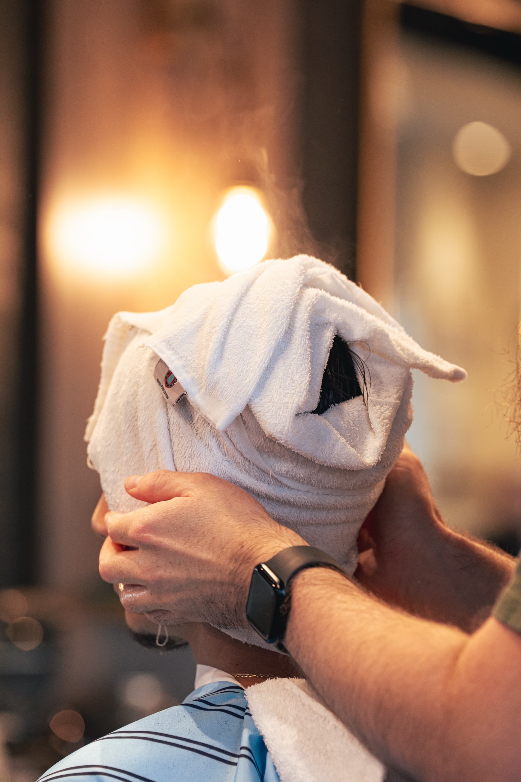 Steaming hot towel wrapped around a client's face