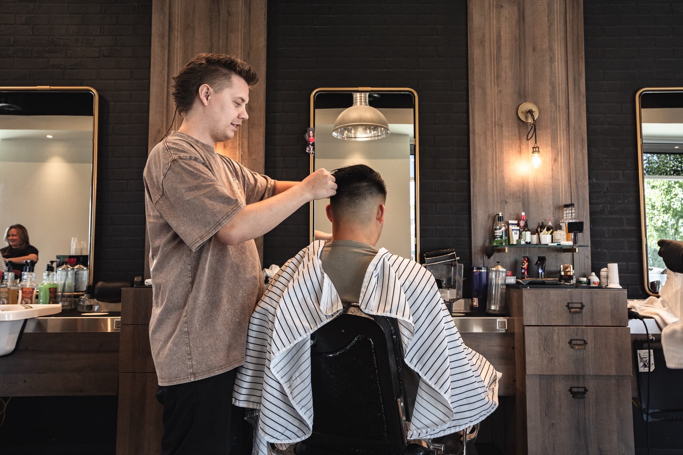 Barber finishing a textured crop with a high fade